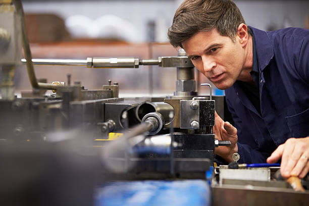 Factory Engineer Operating Hydraulic Tube Bender Close Up Of Factory Engineer Operating Hydraulic Tube Bender machine stock pictures, royalty-free photos & images