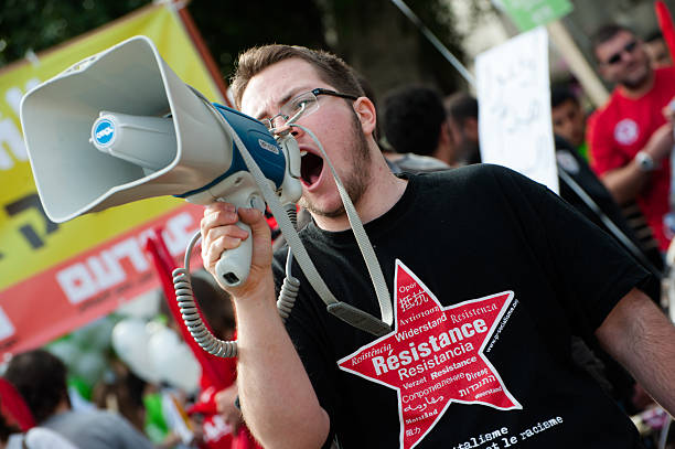 Resistance protester activist Tel Aviv, Israel - December 7, 2012: An activist with a "resistance" t-shirt chants through a megaphone during the annual human rights march in Tel Aviv, Israel. left wing politics stock pictures, royalty-free photos & images