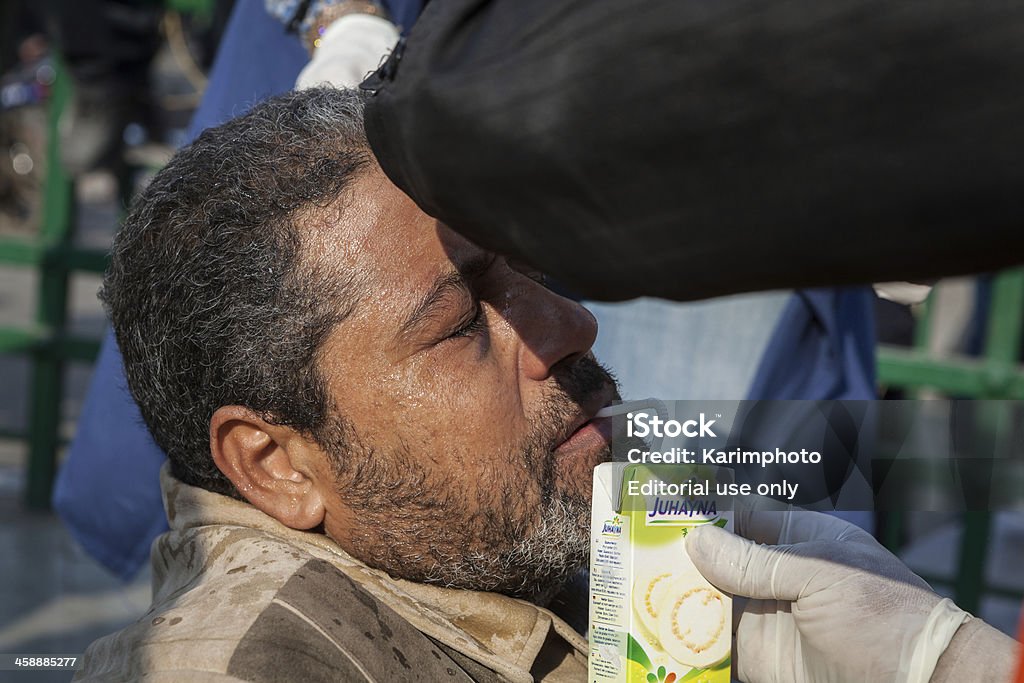 Wounded człowiek otrzymuje pomoc na Tahrir square - Zbiór zdjęć royalty-free (2011)