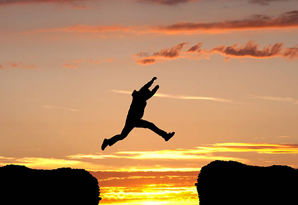 Man leaping into the sunset stock photo