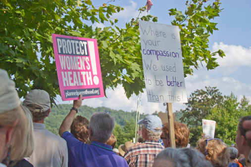 Asheville, North Carolina, USA - August 5, 2013: Protesters hold signs protesting NC state Republican politics at a Moral Monday Rally in Asheville, North Carolina