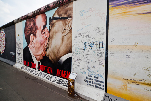 Berlin, Germany - April 19, 2012: piece of the resting Berlin wall, that divided Berlin from 1961 til 1989. The rest of the wall is used by street artists. On this piece of Berlin wall is a historical brother's kiss of Erich Honecker and Leonid Breshnew.
