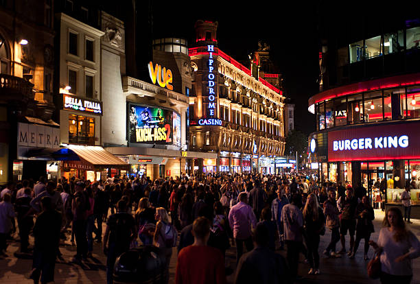 Nightlife in London London, UK - August 16, 2013: people enjoy the Friday nightlife in Leicester Square. Leicester Sq is a pedestrianised square in the West End and is the prime location in London for world leading film premieres. london girl stock pictures, royalty-free photos & images