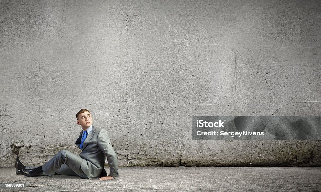 Sitting businessman Image of young businessman sitting lonely on floor Adult Stock Photo