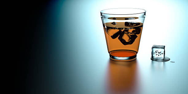 Glass of whiskey with ice cubes stock photo