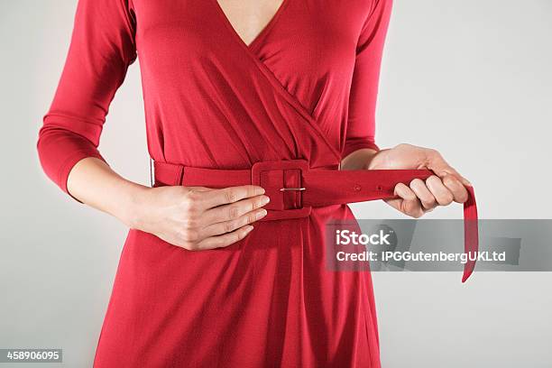 Sezione Centrale Di Donna Daffari Regolando La Cintura - Fotografie stock e altre immagini di Abbigliamento