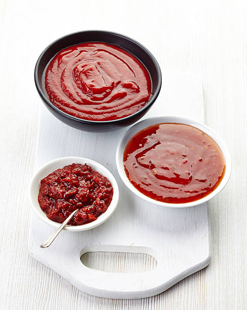 istock Three red sauces in glass bowls on white cutting board 458909557