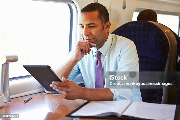 A Businessman Using A Tablet On A Train Stock Photo - Download Image Now - Train - Vehicle, Men, First Class