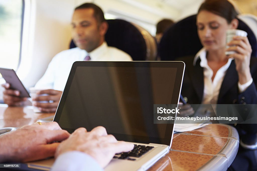 Geschäftsmann die Fahrt zur Arbeit an Zug und Laptop benutzen - Lizenzfrei Beengt Stock-Foto