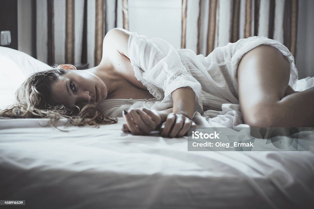 Young sexy woman laying in bed Woman  in bed by window Sexual Issues Stock Photo
