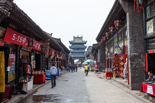 Pingyao, China - May 21, 2011: Chinese tourists visiting Pingyao's main street. Built during the Ming and Qing dynasties, Pingyao is one of the best preserved ancient cities in China with remaining city walls and ancient houses. Houses in the main streets have been converted as tourist shops, restaurants and guest-houses.