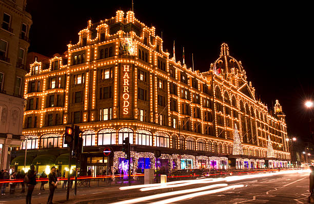 Harrods department store at night, Christmas, London "London, United Kingdom - November 11, 2012: Traffic passing Harrods department store at night, Knightsbridge, London. The store has been decorated for Christmas. Harrods was founded in 1834 it has become world famous and is a popular tourist attraction. Late night shoppers can be seen on the streets outside." harrods photos stock pictures, royalty-free photos & images