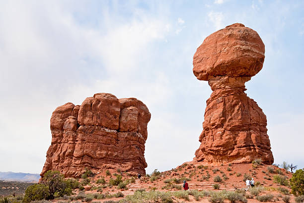 personnes au équilibré et jambon rocks - usa arches national park balanced rock colorado plateau photos et images de collection