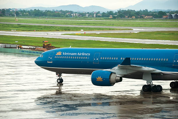 vietnam airlines jet aeroporto di hanoi - runway airport rain wet foto e immagini stock
