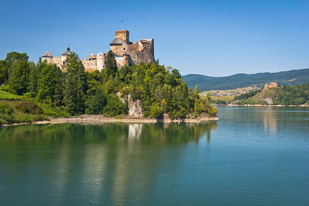 Niedzica, Poland - August 20, 2012: Czorsztyn lake with an old Niedzica Castle  on the hill in Pieniny Mountains, Poland. The Niedzica Castle stands at an altitude of 566 m, on a hill 300 m upstream from the Dunajec River mouth, measured from the center of the dam on Czorsztyn Lake. 