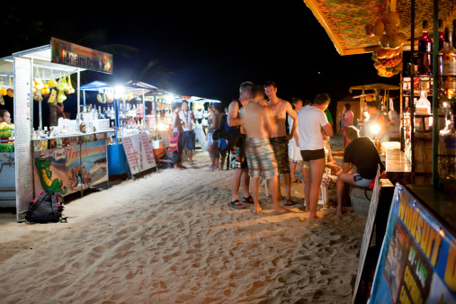 Jericoacoara, Brazil - November 18, 2011: Jericoacoara beach, portable cocktail stalls withpeople, making, buying and drinking coctails made with fresh fruit at night.