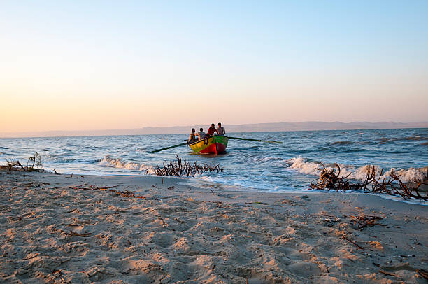 Al Fayoum, Egypt - March 2, 2011: Four Egyptians bring their boat back to shore at sunset after a fishing expedition on Lake Qarun in the Fayoum, Egypt.