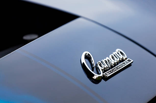 Chevrolet Camaro Emblem Bedford, Nova Scotia, Canada - June 28, 2011: Chevrolet Camaro emblem (Camaro by Chevrolet) on hood of vehicle.  Ahead of logo the engine bay is open and visible.  The Camaro was first introduced in 1966 and is currently in its fifth generation (as of 2011). Chevrolet stock pictures, royalty-free photos & images