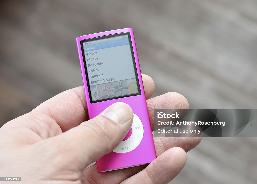 iPod Nano "Vancouver, Canada -- September 12, 2012:Close up of a man's hand holding an older version of the iPod Nano from Apple Inc.  This is the Fourth Generation of the Portable Media Players." iPod Stock Photo
