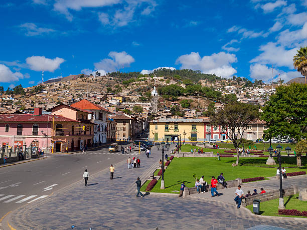 Plaza de Armas, Cajamarca, Peru "Cajamarca, Peru - August 4, 2009: City centre of the remote city of Cajamarca. The Plaza de Armas can be seen with a people sitting and walking about on a sunny day, and a church cross is visible on a a hill in the background. Cajamarca is capital of the Cajamarca region in the northern highlands of Peru and is at an elevation of 2700m above sea level." cajamarca region stock pictures, royalty-free photos & images