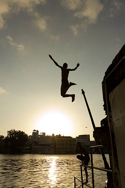 Silhouette of a young man jumping into Lake Pichola (Udaipur) stock photo