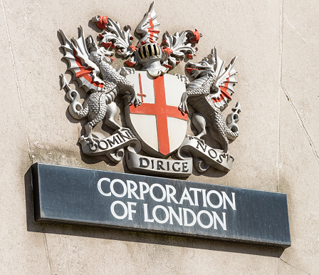 London, UK - April 30, 2012: A traditional, large coat of arms and Corporation Of London sign on a building exterior within the City of London financial district.  The Latin motto 'Domine Dirige Nos' translates as 'Lord guide us'.