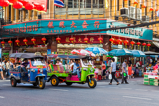 Bangkok, Thailand - January 21, 2012: Thai people are shopping in Bangkok Chinatown while tuktuk (rickshaw) drivers are waiting for clients