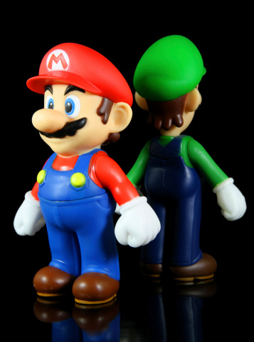 Vancouver, Canada - October 4, 2012: Luigi and Mario from the Nintendo Super Mario franchise of games, posed against a black background. The toys are from Banpresto Company.