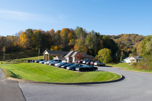 Roan Mountain, TN, USA - October 17, 2012: Cars parked outside Roan Mountain Medical Center, the primary medical facility for this rural mountain community in northeast Tennessee. A work crew is working near the sign.