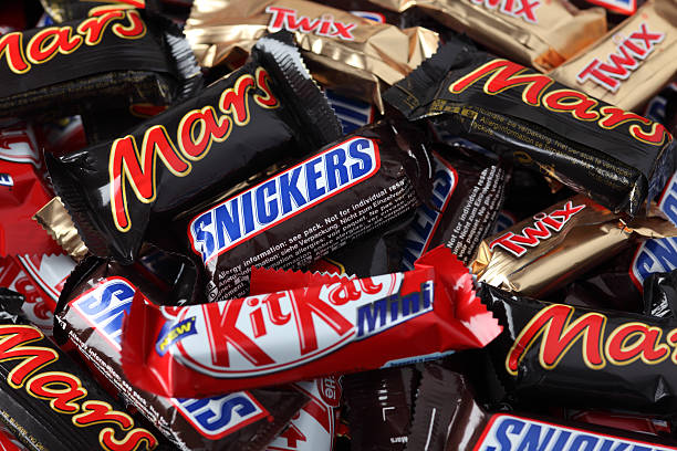 Snickers, Mars, Twix, Kit Kat minis candy bars heap stock photo