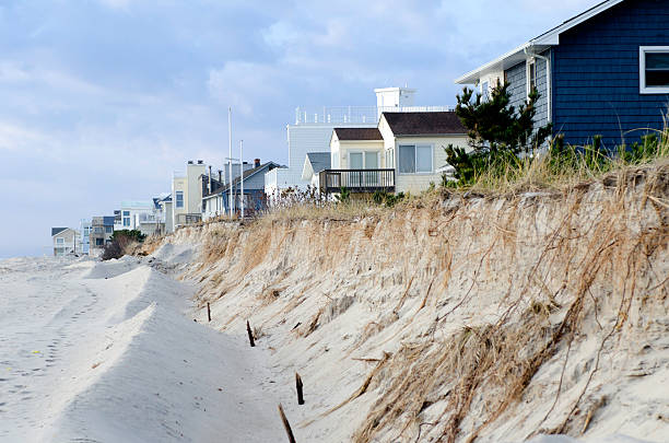 Beach Erosion and Dune Destruction Caused by Hurricane Sandy "Holgate, New Jersey, USA - December 1, 2012: These vulnerable ocean front homes on a barrier island in Holgate, New Jersey, now sit on the very edge of the sea; due to the beach erosion and dune destruction caused by Hurricane Sandy, in late October of 2012." eroded stock pictures, royalty-free photos & images