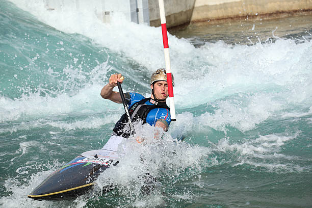 London, United Kingdom - March 30, 2012:  In the Lee Valley White Water Centre,  Station Road, Waltham Cross, Hertfordshire EN9 1AB in Greater London, a canoeist practices his slalom  skills at white water kayaking in the rapids of this artificial course.