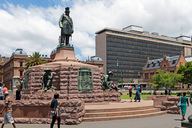 Pretoria, South Africa - October, 28th 2012: Church Square in Pretoria / Tshwane, showing Paul Kruger statue looking down at tourists taking pictures of children with the statue of Piet Retief.