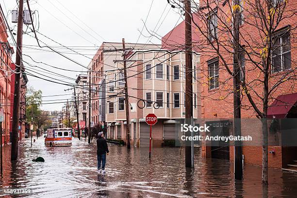 Hurricane Sandy Man Standing On A Flooded Street Stock Photo - Download Image Now - Flood, Hurricane Sandy, New Jersey
