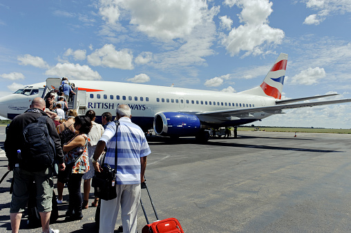 Victoria Falls Town, Zimbabwe - April 8, 2012: Tourists with hand luggage embarking on the British Airways flight 6282 operated by Comair,a South African aviation company.The Boeing  737-300 will be flying from  from Victoria Falls Town to Johannesburg in South Africa. 
