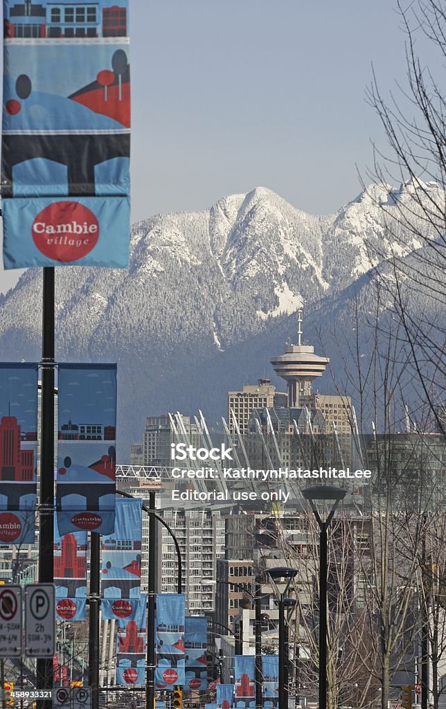 Vancouver's Cambie Village, Downtown and North Shore Mountains "Vancouver, Canada - February 27, 2012:Colorful banners in Cambie Village line the street. BC Place Stadium and the Harbour Centre Vancouver Lookout are large landmarks downtown. The North Shore Mountains feature snow on a winter morning." Vancouver - Canada Stock Photo