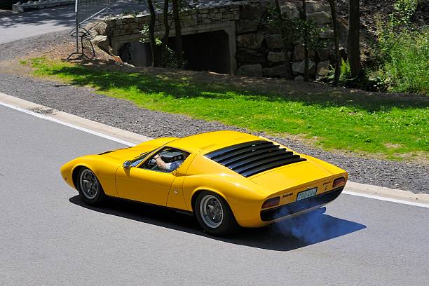 Lamborghini Miura S Spa, Belgium - June 29, 2008: Yellow Lamborghini Miura S classic sports car driving in a corner at the Spa Francorchamps race track during the 2008 Spa Italia days. The driver is steering into the corner. lamborghini miura stock pictures, royalty-free photos & images