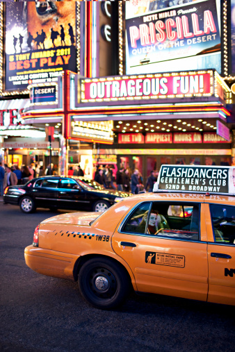 New York, United States - March 16, 2012: Woman in a Taxi going through the 7th avenue in Times Square full of neons and billboards and part of the theater district in Manhattan.