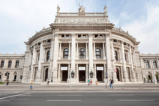 Tram passes in front of the ornate facade of the Burgtheater in downtown Vienna, Austria at twilight.