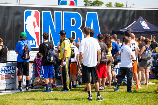 Halifax, Nova Scotia, Canada - September 8, 2012: Crowd of people at the NBA 3X in downtown at the Commons in Halifax, Nova Scotia.  Many people of different ages attend with NBA logo visible on trailer in background.  The NBA 3X is a public event that tours across Canada.  Local players can register to play 3 x 3 basketball during the event.