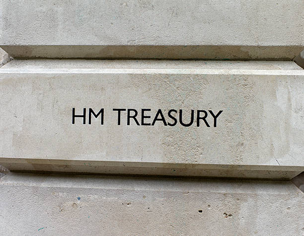 HM Treasury sign "London, England - June 2, 2012: A simple, restrained, wall sign outside the British Treasury building at 1 Horse Guards Road, just off Whitehall, London. Her Majestys Treasury is the ministry responsible for the economy and the nations finance and the Chancellor of the Exchequer is the most senior minister in this department. The history of the Treasury dates back to the Norman Conquest and the department has always been based in the Whitehall area - previously, the Royal Treasure was kept in Winchester. (Overcast with light rain.)" hm government stock pictures, royalty-free photos & images