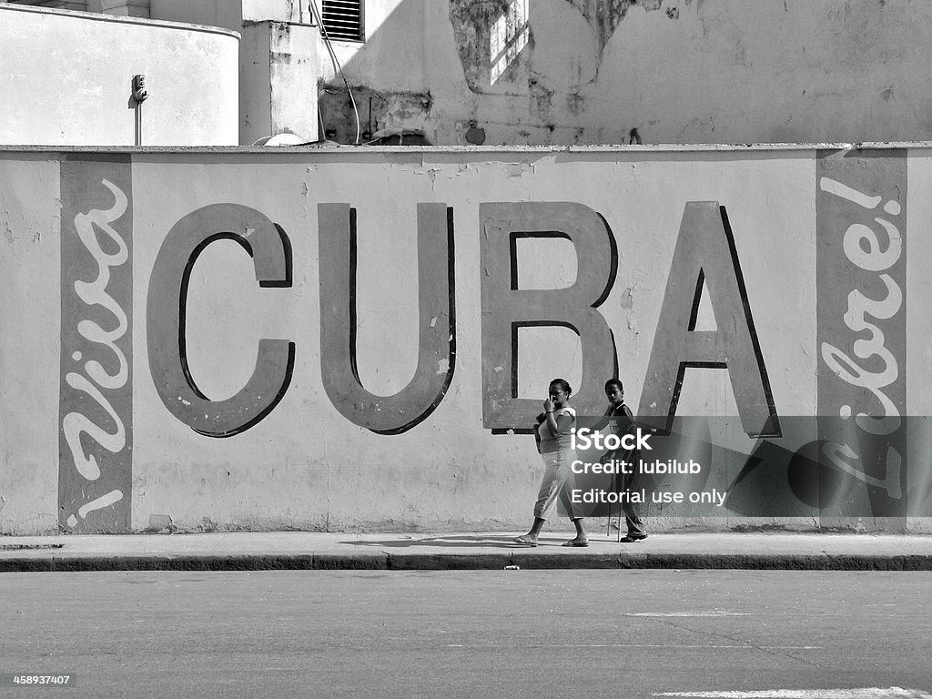 Madre e hijo pasar por un muro en la Habana, Cuba - Foto de stock de Fidel Castro libre de derechos