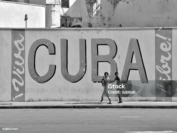 Madre E Hijo Pasar Por Un Muro En La Habana Cuba Foto de stock y más banco de imágenes de Fidel Castro - Fidel Castro, Abrazar, Acera