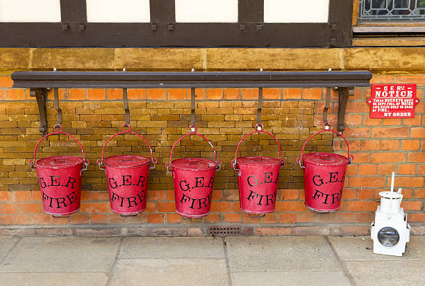 Wolferton, England - September 18, 2012: A row of fire buckets at the former railway station at Wolferton, Norfolk. The railway line was the Great Eastern Railway - which is why the buckets bear the initials G.E.R. - and the line was closed in 1969.