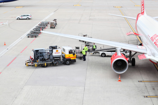 zurich, switzerland  - October 14, 2012:An Air Berlin flight has arrived at Zurich Airport.  While the aircraft is docked, it is refuelled with the help of a Shell mobile pumping vehicle. Baggage handlers are also working to turn the aircraft around for departure.