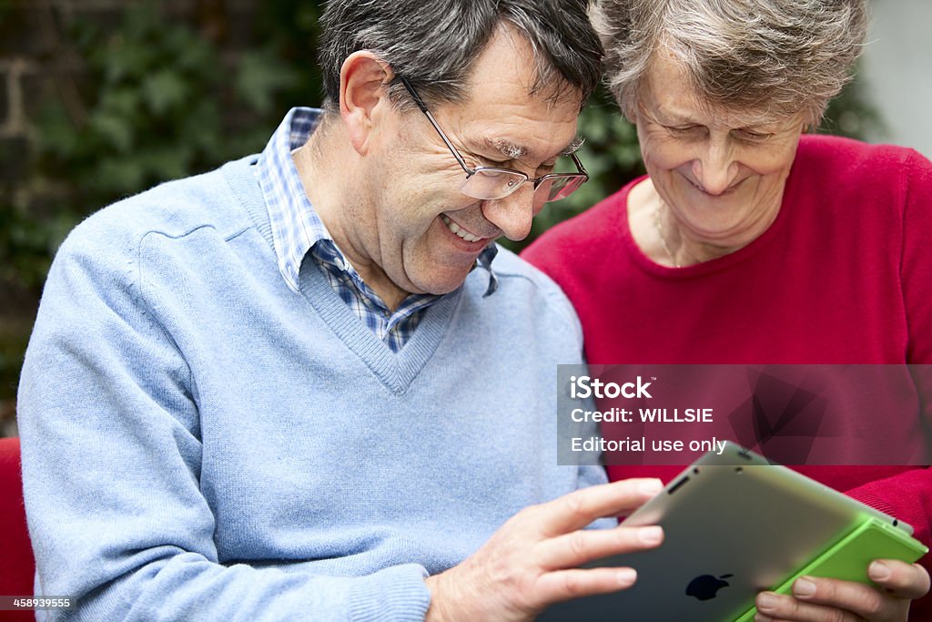 Dois adultos olhar para o ecrã de um iPad 2-alegre - Royalty-free Adulto Foto de stock