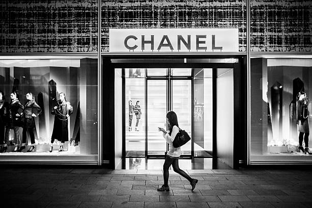Tokyo, Japan - October 13, 2012: Women walking in front of Chanel luxury store in Ginza Tokyo Japan. This luxury brand founded in 1909 by Coco Chanel specializes in high couture to perfumes and other luxury goods. With over 300 shops worldwide this shop in Ginza is the flagship store in Japan.