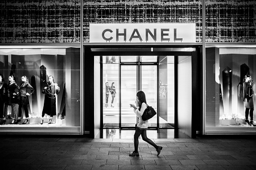 Tokyo, Japan - October 13, 2012: Women walking in front of Chanel luxury store in Ginza Tokyo Japan. This luxury brand founded in 1909 by Coco Chanel specializes in high couture to perfumes and other luxury goods. With over 300 shops worldwide this shop in Ginza is the flagship store in Japan.