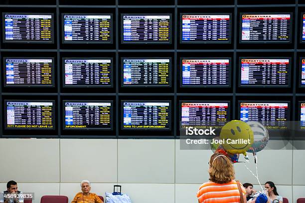 Photo libre de droit de Femme À La Recherche À Larrivée À Laéroport De banque d'images et plus d'images libres de droit de Aéroport - Aéroport, Ballon de baudruche, Soulever