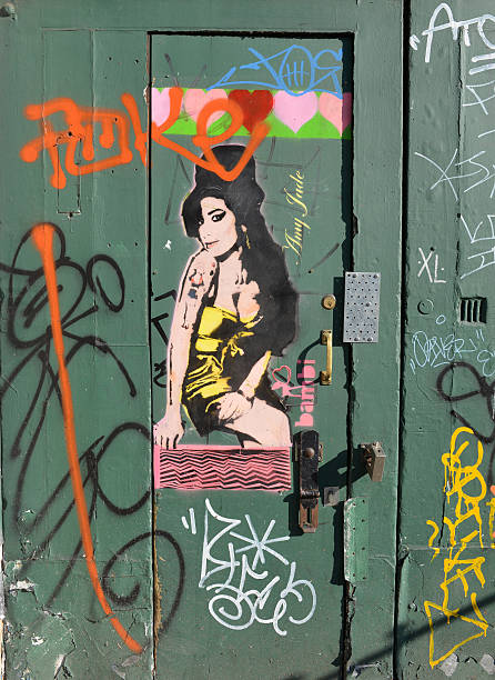 Camden Graffiti "London, UK - September, 3rd 2012: An entrance doorway in Camden road, covered with graffiti....with a graffiti portrait of deceased singer Amy Winehouse who lived in Camden" camden market stock pictures, royalty-free photos & images